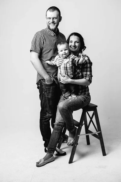 Retrato preto e branco de uma família com um menino Fotos De Bancos De Imagens