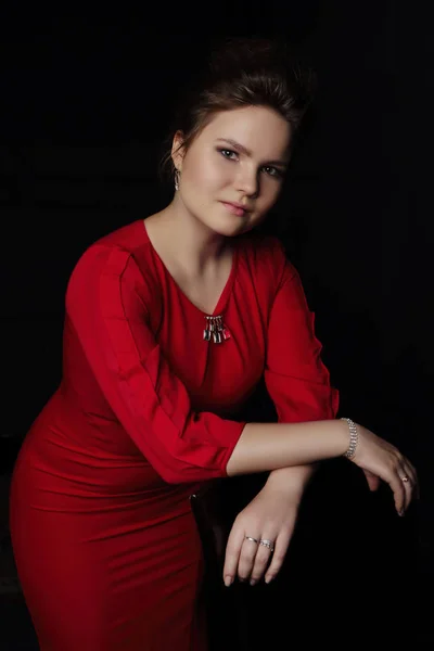 Портрет молодой женщины в красном платье темный фон — стоковое фото