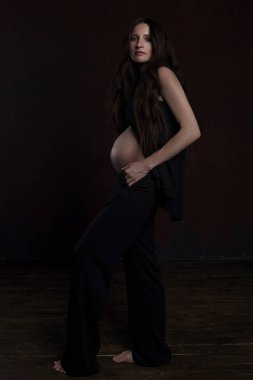 koyu arka plan üzerinde güzel hamile kadın 