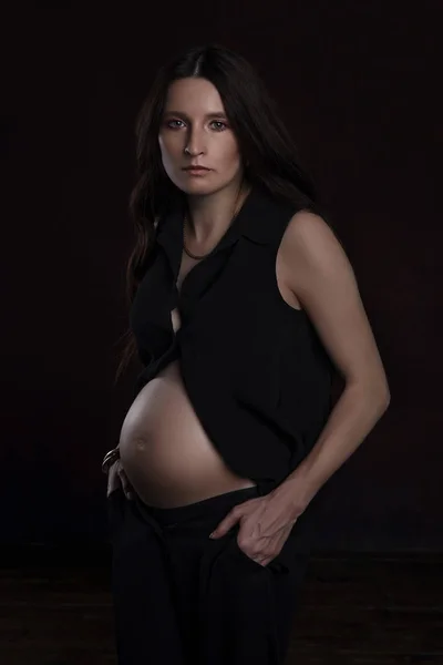 Красива вагітна жінка на темному тлі — стокове фото