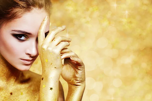 Altın pırıltılar arka plan üzerinde güzel kadın