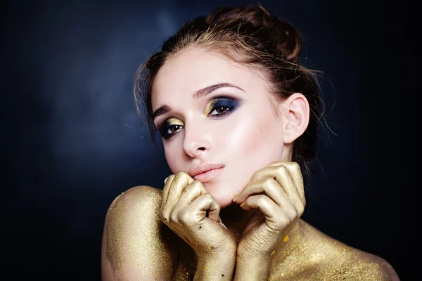 Mujer glamurosa con maquillaje dorado sobre fondo azul — Foto de Stock