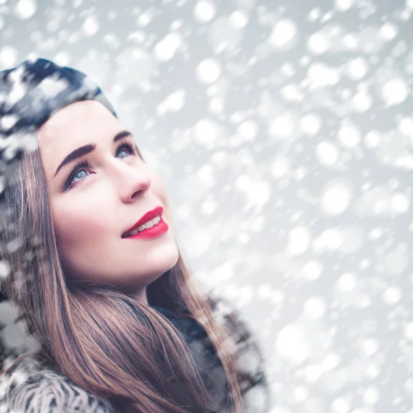 Schöne Modell Frau Blick nach oben auf Schneefall Winter Hintergrund. — Stockfoto