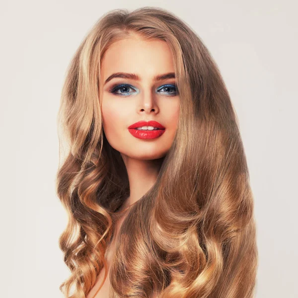 Healthy Woman with Long Blonde Hair and Makeup. Permed Hairstyle