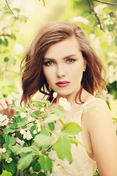 Söt flicka i Spring Park. Mode modell kvinna på blommor och Gre — Stockfoto