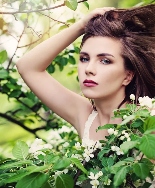 Jarní Model mladá žena s foukáním účes na květy zpět — Stock fotografie