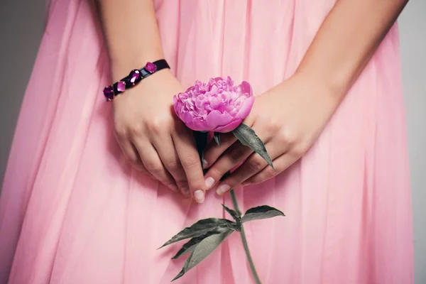 Bellissimo fiore di peonia in mani femminili sulla gonna da ballo in pizzo — Foto Stock
