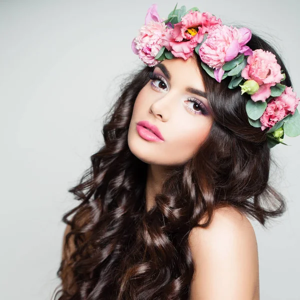 Het gezicht van de schoonheid. Leuke vrouw met krullend en bloemen — Stockfoto