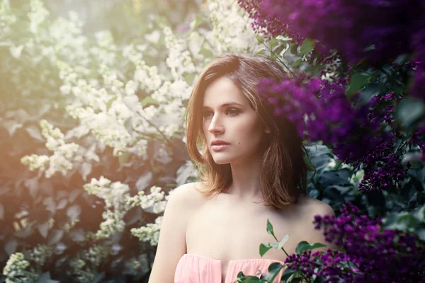Piękna kobieta w Liliowe kwiaty w słońcu. Piękna wiosna na B — Zdjęcie stockowe