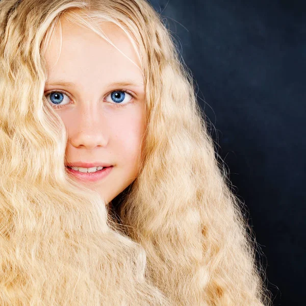 Hübsches Kind Mädchen auf blauem Hintergrund. lange blonde Haare, Gesicht klo — Stockfoto