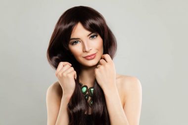 Uzun kahverengi ipeksi saç ve makyaj arka plan üzerinde şirin kadınla. 