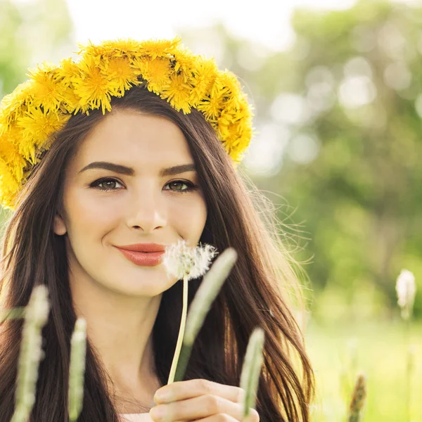 微笑与蒲公英的花在绿色草地上的女人 — 图库照片