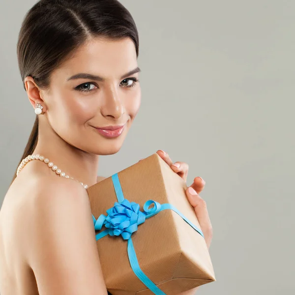Elegante mujer modelo de moda sosteniendo caja de regalo con cinta azul —  Fotos de Stock