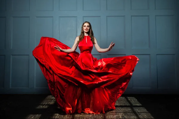 Prachtige Fashion Model vrouw in rode zijdeachtige jurk. — Stockfoto
