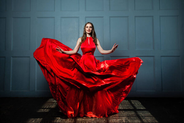 Beautiful Fashion Model Woman in Red Silky Dress.
