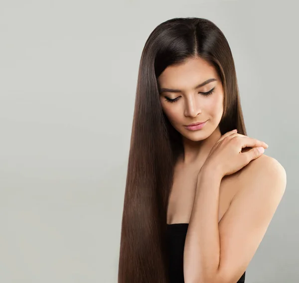 Mulher modelo perfeito com cabelo longo e saudável no fundo cinza — Fotografia de Stock