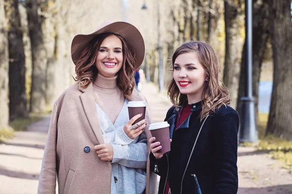 Deux filles buvant du café et bavardant dans le parc d'automne — Photo