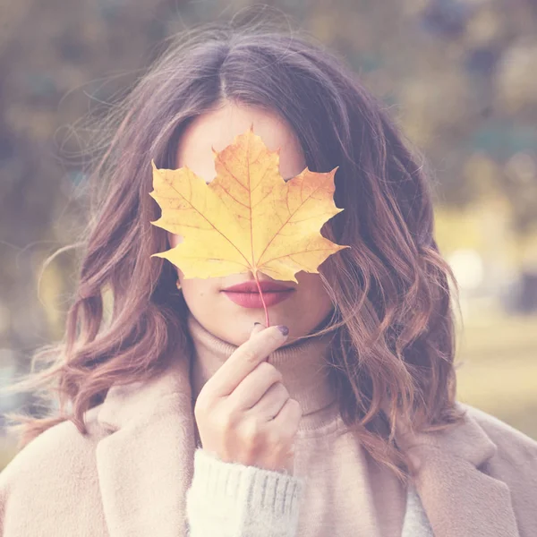 Schöne Herbstfrau mit gelbem Apfelblatt im Freien. roma — Stockfoto