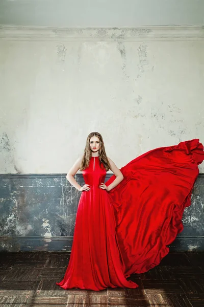 Μόδα μοντέλο γυναίκα με τα κόκκινα φυσώντας μεταξένιο φόρεμα — Φωτογραφία Αρχείου