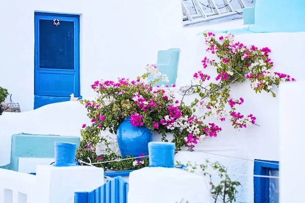 Grekiska hus med blå dörr och färgglada blommor, Grekland — Stockfoto