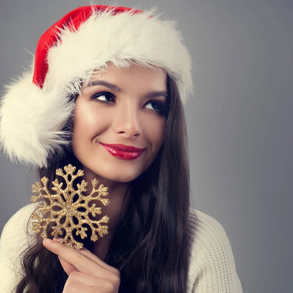 Hermosa mujer de Navidad en Santa Sombrero celebración de copo de nieve de oro —  Fotos de Stock