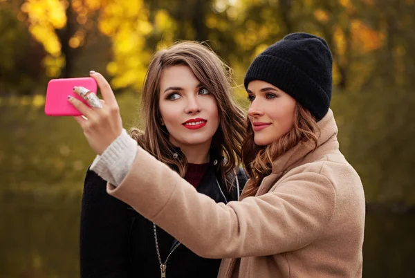 Słodkie dziewczyny modeli ze smartfona biorąc Selfie na zewnątrz. Jesień — Zdjęcie stockowe