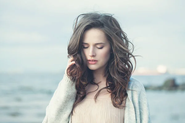 Porträtt av en vacker tjej med lockigt hår på en kall blåsig dag — Stockfoto