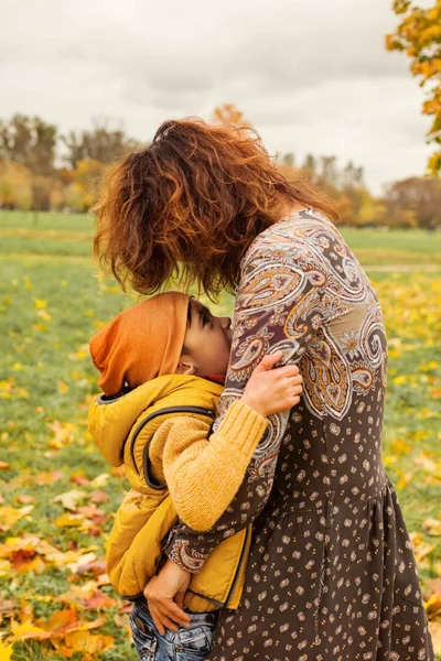 Happy Autumn Family. Cute Mother and Son  Hugging in Fall Park