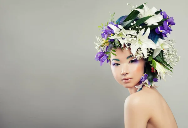 Belle femme avec des fleurs et du maquillage de mode — Photo