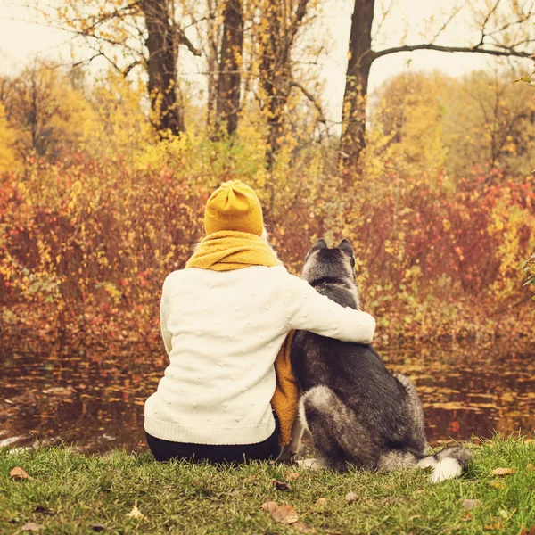 Mujer joven y perro Husky en el parque de otoño al aire libre —  Fotos de Stock