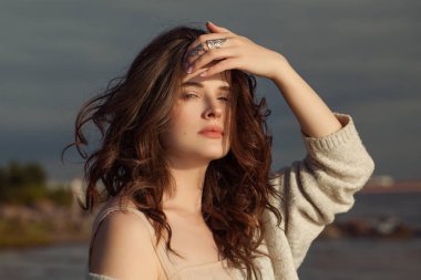 Kıvırcık saçları ve doğal makyaj üfleme güzel kadın 