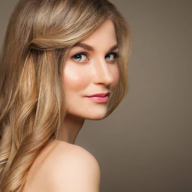 Bej renkli arka plan üzerinde sarı saçlı sevimli Model kadın