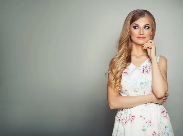 Beautiful Woman with Blonde Wavy Hairstyle and Makeup Looking Up Stock Picture