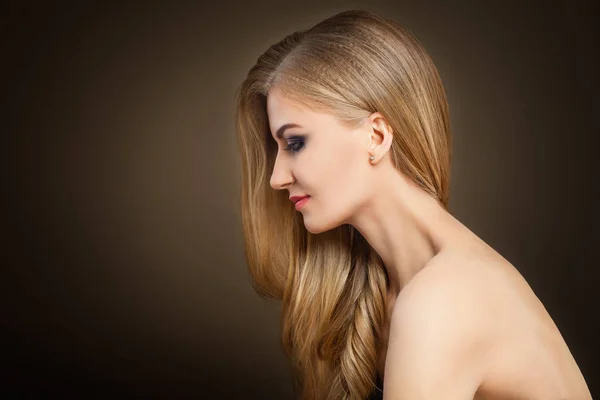 Gezonde Blonde vrouw met lange haren op donkere achtergrond — Stockfoto