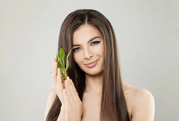 Vacker brunett kvinna med grön bambublad — Stockfoto