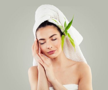 Spa modeli kadınla sağlıklı cilt, beyaz havlu ve yeşil bambu 