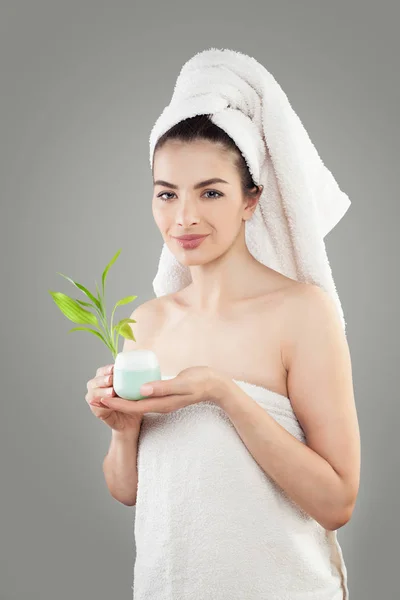 Modelo de Spa Mujer sosteniendo crema cosmética y hojas de bambú —  Fotos de Stock