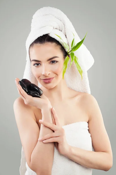 Atractiva modelo de spa sosteniendo piedras negras calientes. Mujer joven Spa —  Fotos de Stock
