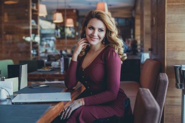 Gülümseyen kadın restoranda. Güzel Model Cafe oturuyor