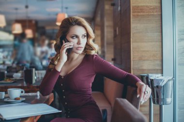 Genç kadın tek başına otururken hücre telefon ile arama