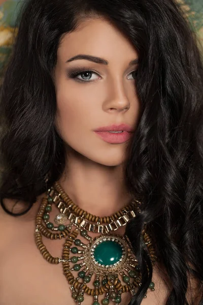 Perfecte jonge vrouw met lang krullend haar en groene ketting — Stockfoto
