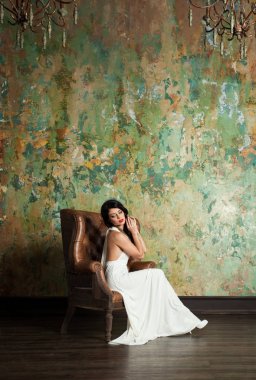 Çekici kadın moda Model oturan Vintage koltuk üzerinde