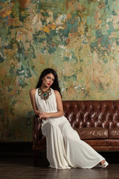 座っている白いイブニング ・ ドレスで美しい若いモデル — ストック写真
