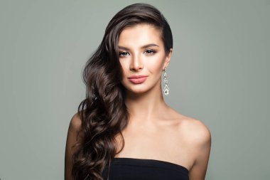 uzun kıvırcık saçları gri arka plan üzerine güzel bir esmer kadın