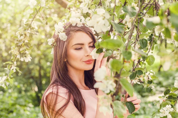 Glad ung kvinna att lukta blommor i blossom vårblommor — Stockfoto