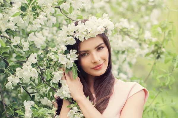 Trevlig ung kvinna ler och hålla blommor — Stockfoto