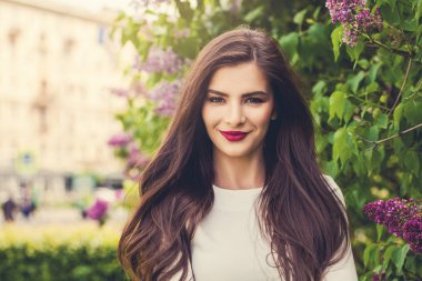 Kadın açık havada gülümseyerek. Neşeli modeli esmer makyaj ile