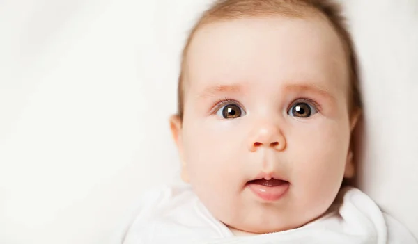 Mooie kleine baby gezicht, portret. Nieuwsgierig klein kind — Stockfoto
