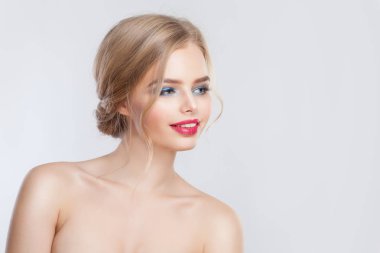 Genç sarışın kadın beyaz arka planda bir tarafa bakıyor.