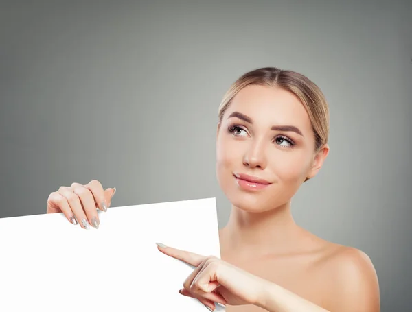 Healthy woman with clear skin holding empty white card singboard — Stockfoto